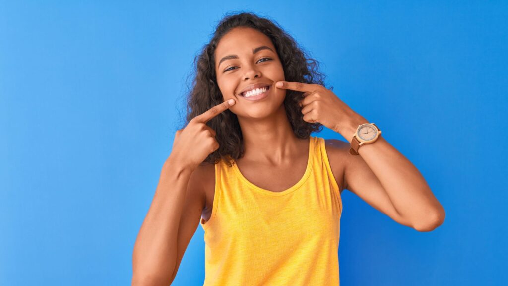 adult points to clean teeth after Dental cleanings with braces